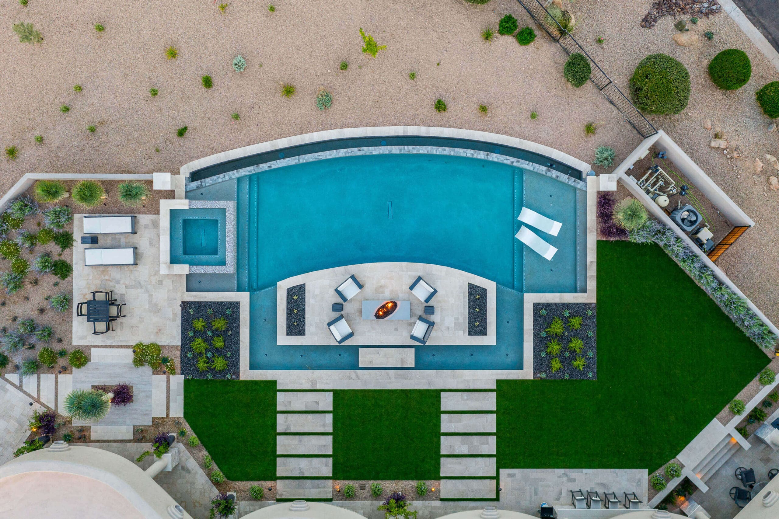 Aerial view of a luxury Arizona backyard with travertine, turf, and desert planting