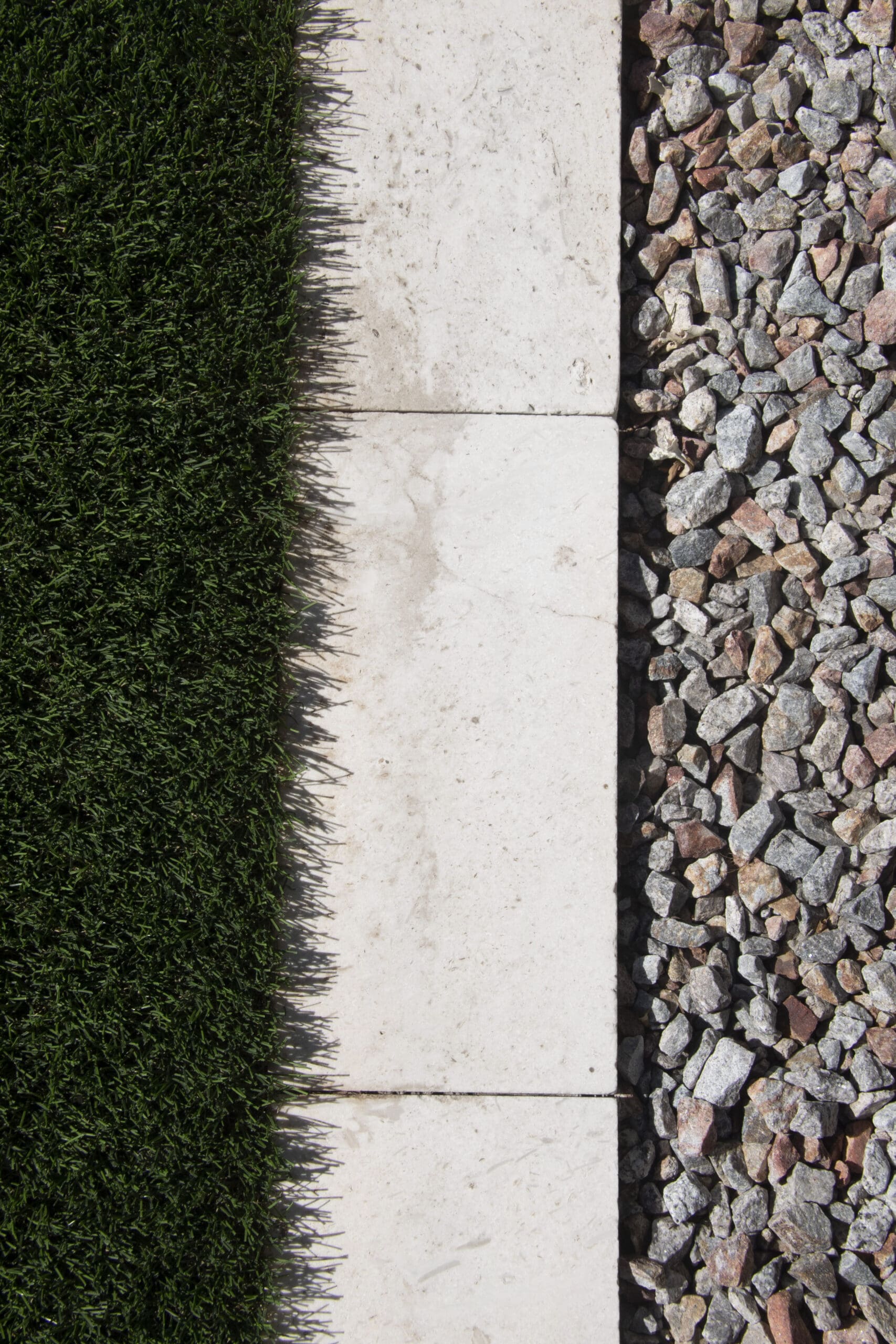 Alternating stone pavers and turf strips in a modern East Valley backyard